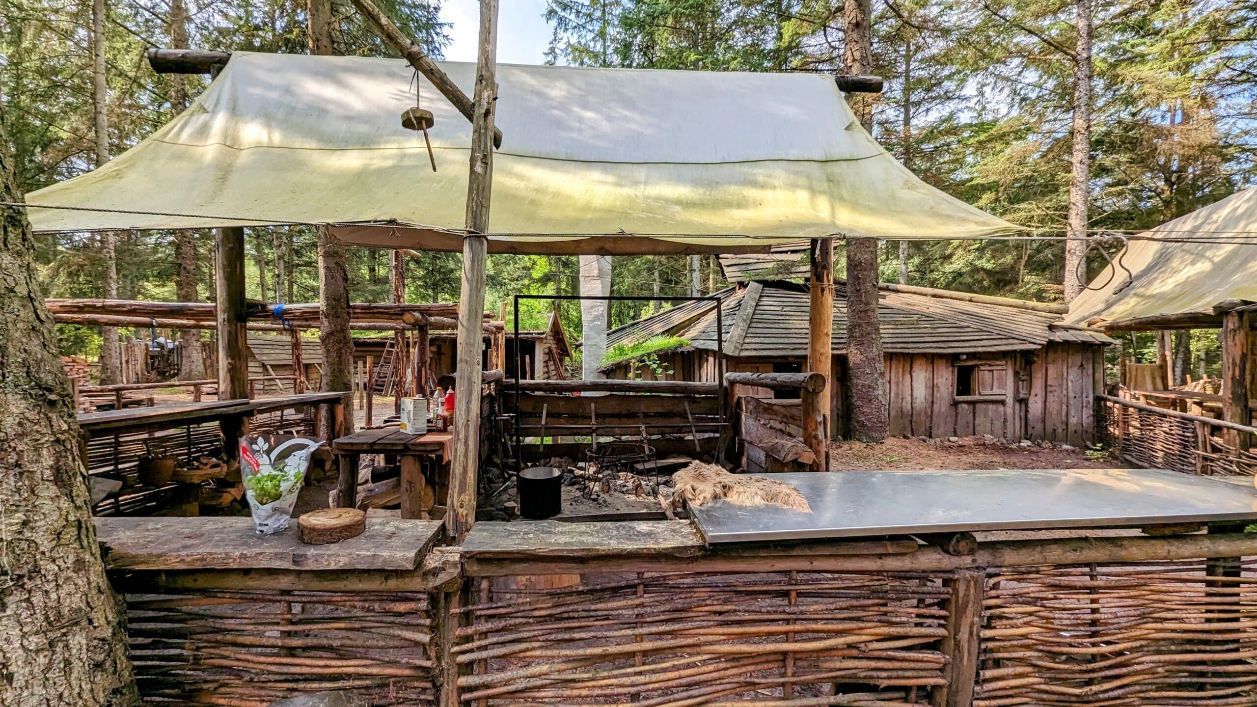 Eine Hütte im Wald mit Tisch und Stühlen.