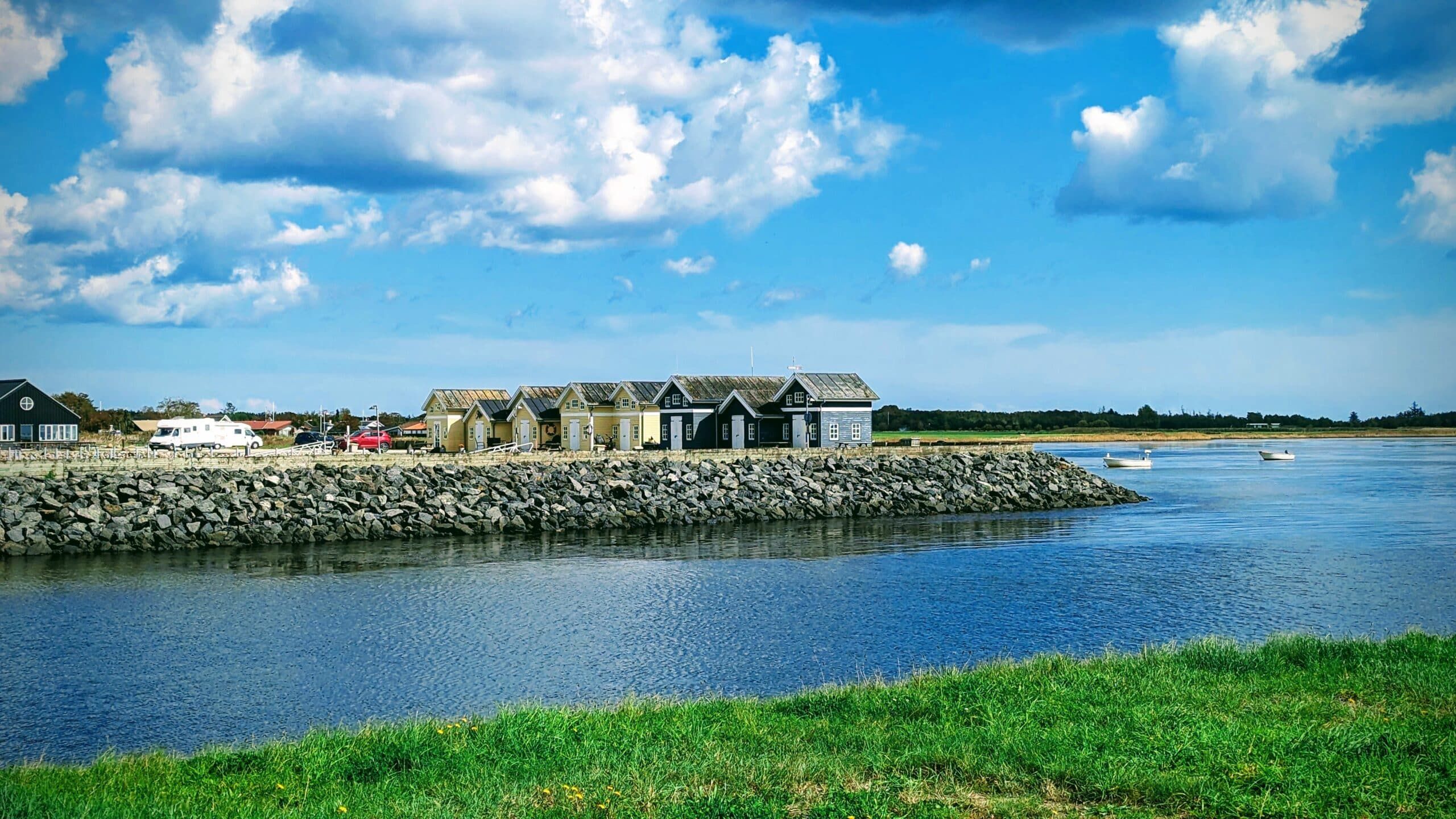 Eine Häusergruppe am Ufer eines Gewässers.